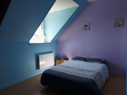 a bedroom with a bed and a blue wall at Guingamp centre : grand appartement lumineux in Guingamp