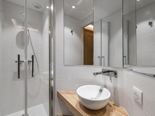 uma casa de banho branca com um lavatório e um chuveiro em Appartement Méribel, 3 pièces, 6 personnes - FR-1-565-29 em Les Allues