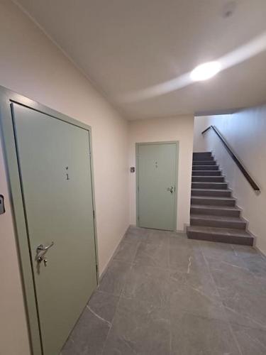 an empty hallway with stairs and a door and a staircase at Nadmar hostel apartment, no.1 in Kuressaare