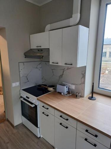 a kitchen with white cabinets and a stove at Nadmar hostel apartment, no.1 in Kuressaare