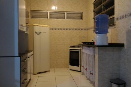 een keuken met een koelkast en een fornuis bij MARAVILHOSA CASA EM BÚZIOS AO LADO DO CENTRO in Búzios