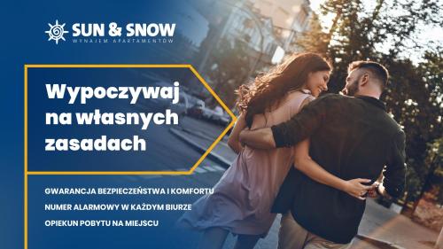 plakat mężczyzny i kobiety stojących na ulicy w obiekcie Apartamenty Sun & Snow w Novum Kraków w Krakowie
