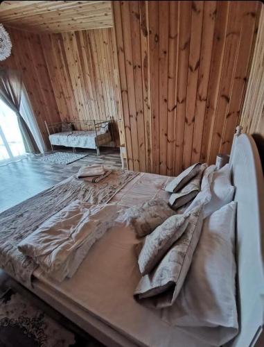 a large bed in a room with wooden walls at Relax villa Poduzska in Sinyak