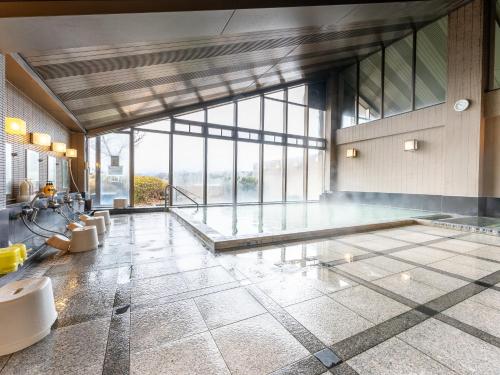 a large room with a swimming pool with a large window at Healthy Pal Akagi in Shibukawa