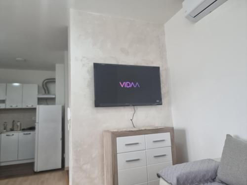 sala de estar con TV en la pared en Klub1, en Podgorica