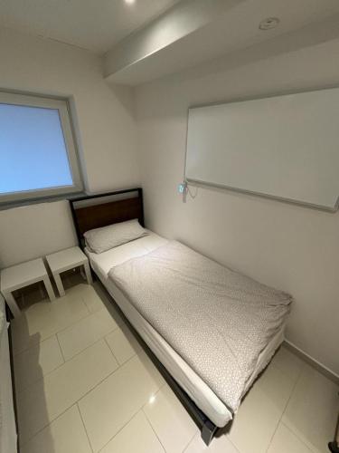 um pequeno quarto com uma cama e uma janela em MK Apartments Bremen 2 em Bremen