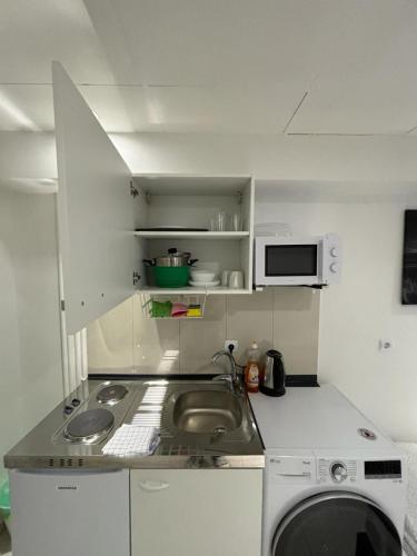 uma pequena cozinha com um lavatório e uma máquina de lavar roupa em MK Apartments Bremen 2 em Bremen