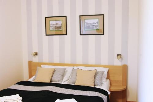 a bedroom with a bed with three pictures on the wall at Švihák lázeňský in Velké Losiny