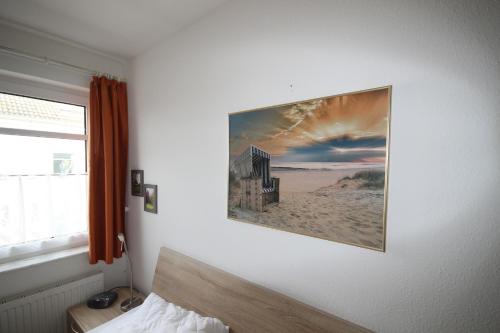 1 dormitorio con una foto colgada en la pared en Atlantic 29, en Grömitz