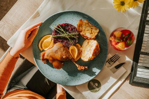 einen Teller mit Hühnchen und Orangen auf dem Tisch in der Unterkunft Villa Betula Resort & Camping in Liptovská Sielnica