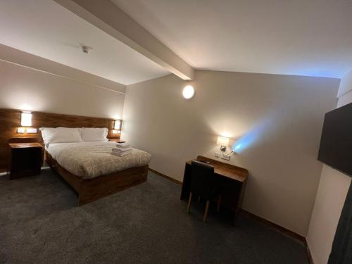 1 dormitorio con cama, escritorio y luces en Burntisland House, en Burntisland