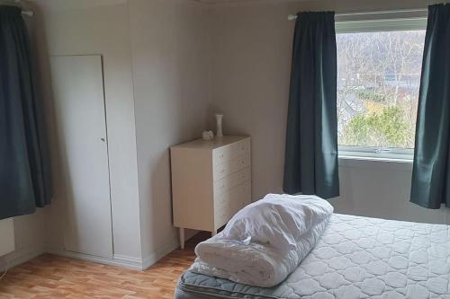 a bedroom with a bed and a dresser and a window at Madsgård in Etnesjøen