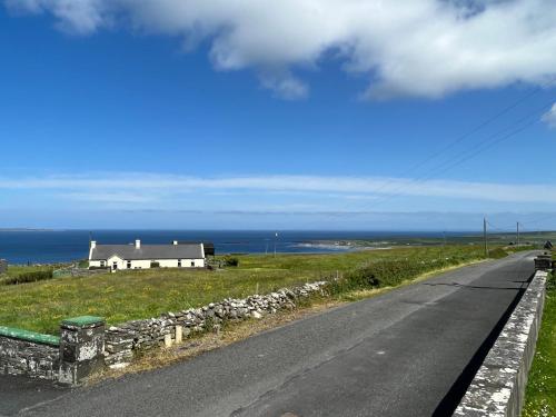 a road with a house on the side of a hill at Ocean View Doolin in Doolin