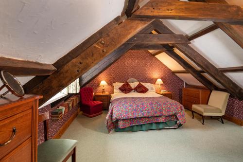 a attic bedroom with a bed and a chair at Upper Cottage Drefach Felindre in Cwm-pengraig