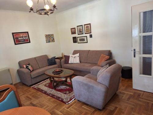 ein Wohnzimmer mit einem Sofa und einem Tisch in der Unterkunft Apartment Music-center, in the center of Podgorica in Podgorica