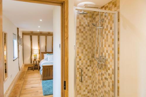 a bathroom with a shower with a glass door at The Thatched Barn in Brabourne