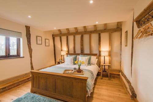 a bedroom with a large bed with a wooden headboard at The Thatched Barn in Brabourne
