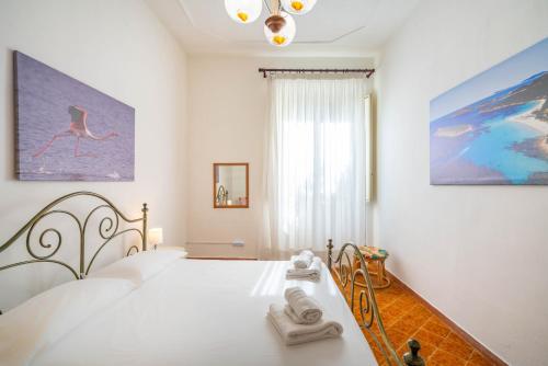 a white bedroom with a bed with towels on it at Al Bastione in Cagliari