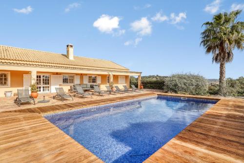 a swimming pool in front of a house at Casa de Apra by Portucasa in Loulé