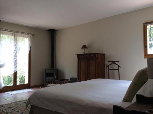 een slaapkamer met een groot wit bed en een raam bij La Suite, Les Hautes Roches in Collobrières