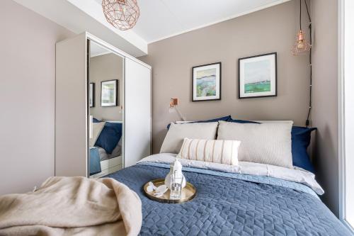 1 dormitorio con cama azul y espejo en Charming and cozy - Centrally located en Oslo
