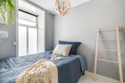 a bedroom with a blue bed and a ladder at Charming and cozy - Centrally located in Oslo