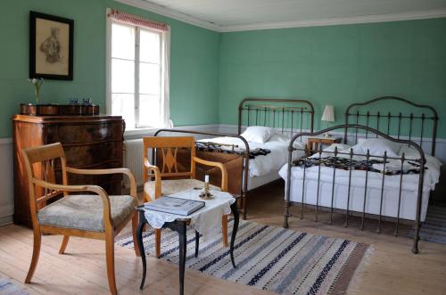 een slaapkamer met 2 bedden en een tafel en stoelen bij Nästegården Bed & Breakfast in Sätuna