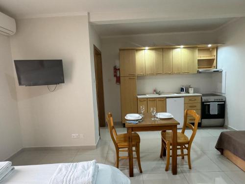 a kitchen and dining room with a table and chairs at The Triton in St. Paul's Bay