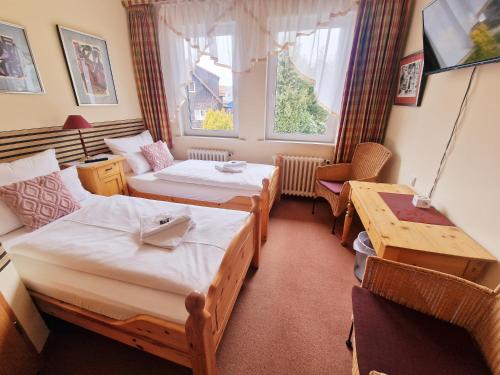 a small room with two beds and a table at Hotel Elisabeth Ilse in Braunlage