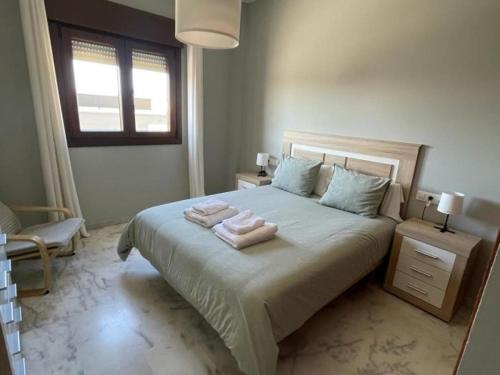 a bedroom with a bed with two towels on it at Lux Bormujos - Vacacional Sevilla in Bormujos