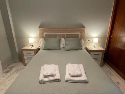 a bedroom with a large bed with towels on it at Lux Bormujos - Vacacional Sevilla in Bormujos