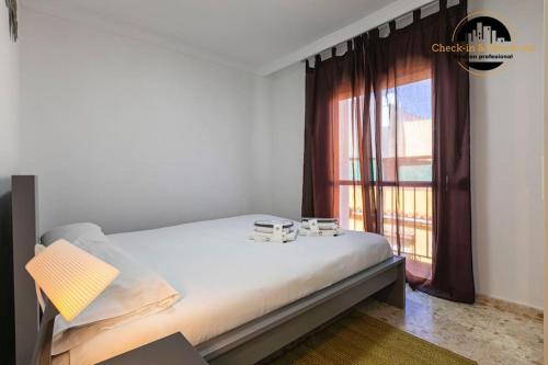 a bedroom with a bed and a large window at Apartamento Las Redes Estepona in Estepona