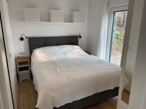 a bedroom with a large bed with a window at Nussknackerhaus in Sankt Kanzian