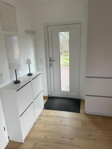 una habitación con armarios blancos y una puerta a un patio en Nussknackerhaus, en Sankt Kanzian
