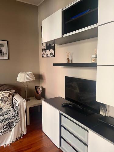 a bedroom with a desk with a television and a bed at Easy Milano - Rooms and Apartments Navigli in Milan