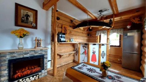 a living room with a fireplace in a log cabin at Willa Pośrednia in Zakopane