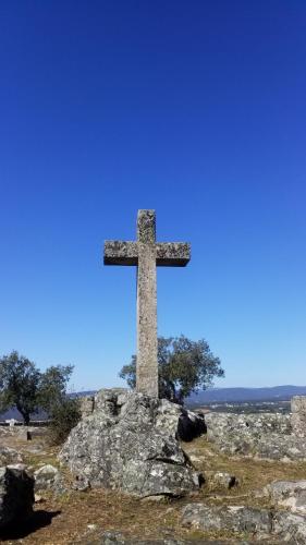 a cross on top of a rock in a field at Casa Carini in Sertã