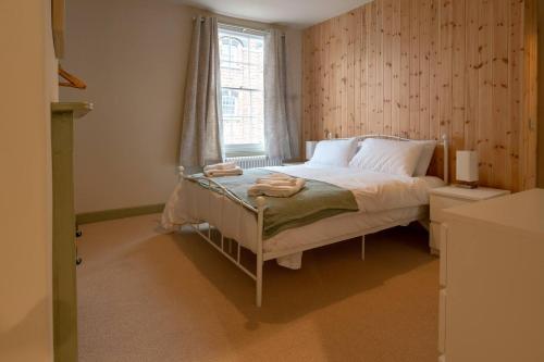 a small bedroom with a bed with a window at Pass the Keys Stylish Grade II listed house in Cheltenham