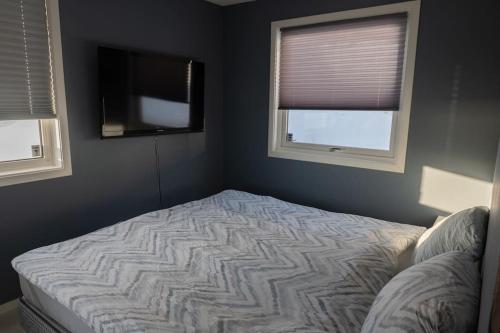 a bedroom with a bed and a flat screen tv at Panorama view! Modern,Balcony/parking in Bodø