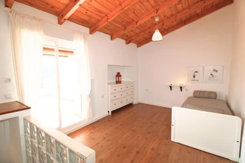 1 dormitorio con 1 cama, vestidor y ventana en Casa Platero by SIERRA VIVA, en Galaroza