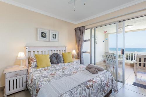 a bedroom with a bed with a view of the ocean at Laguna La Crete 5 in Uvongo Beach