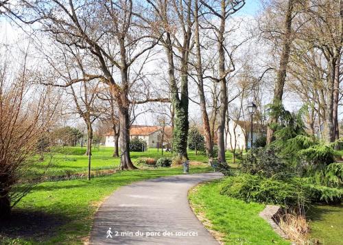 eine kurvenreiche Straße in einem Park mit Bäumen und Gras in der Unterkunft Bed & Breakfast - Entre Paris & Disneyland in Roissy-en-Brie