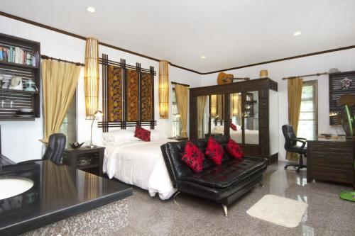 a bedroom with a large bed with red pillows at The Green Palm in Haad Pleayleam