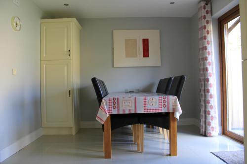 a dining room table with black chairs and a tablecloth at Cosy Holidayhomes Kenmare in Kenmare