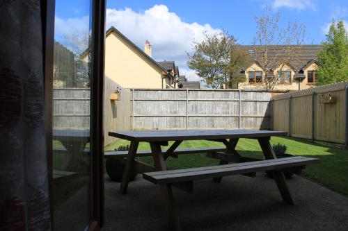 a picnic table in a backyard with a fence at Cosy Holidayhomes Kenmare in Kenmare