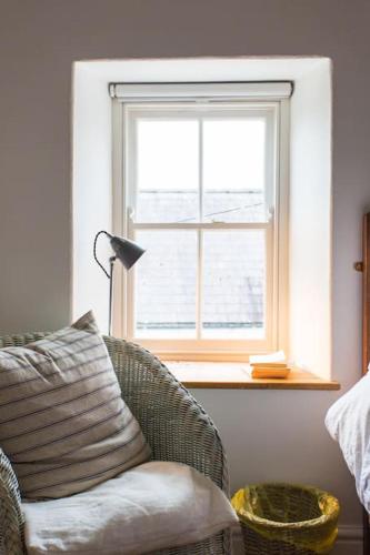 a living room with a chair and a window at Quay Cottage Llandeilo in Llandeilo