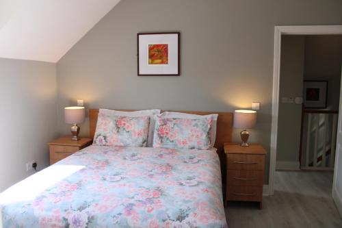 sypialnia z łóżkiem i 2 szafkami nocnymi z lampkami w obiekcie Cosy Holidayhomes Kenmare w mieście Kenmare