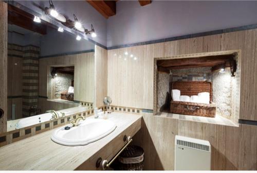 a bathroom with a sink and a large mirror at Auténtica casa rural con encanto by beBalmy in Sorihuela
