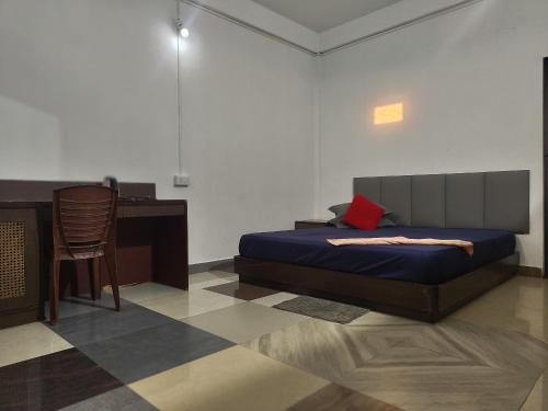 una camera con letto, scrivania e sedia di The Green Garden Retreat, Dooars a Sukhani