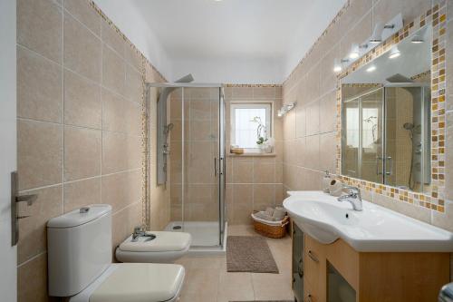 a bathroom with a toilet and a sink and a shower at Casa Alegria Carvoeiro in Carvoeiro